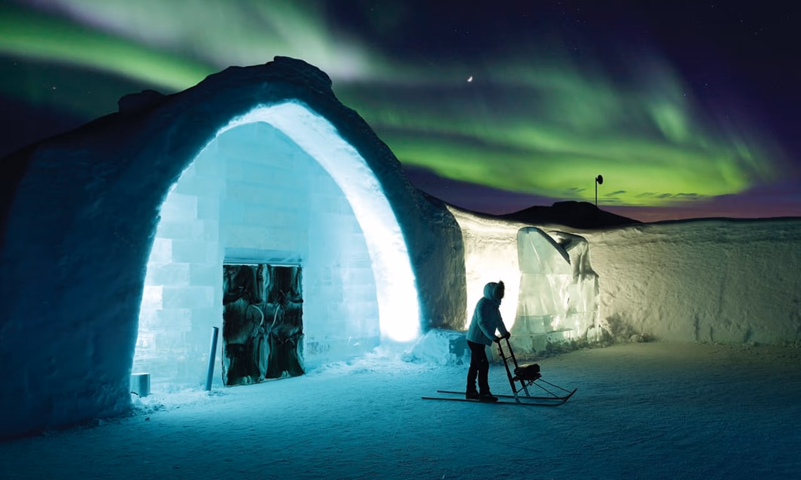 A glowing ice dome under the northern lights
